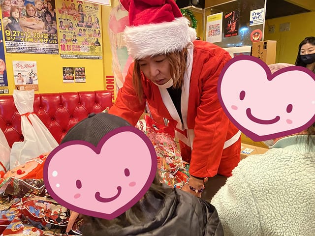 サンタの扮装でプレゼントを配る様子